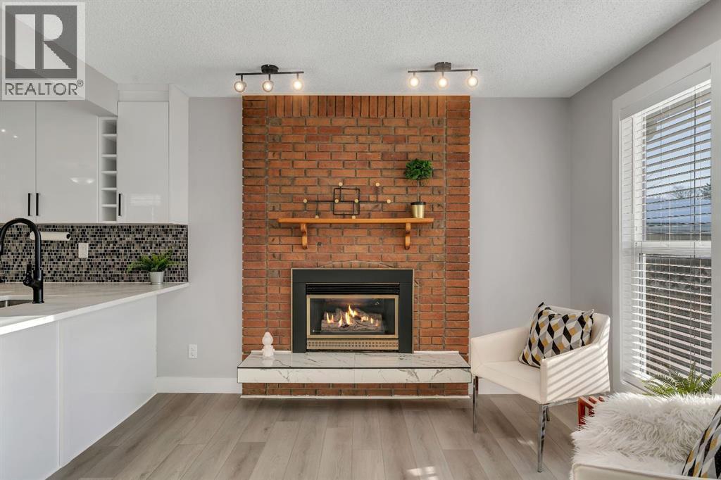 17 Mckernan Road Se, Calgary, AB - Indoor Photo Showing Living Room With Fireplace