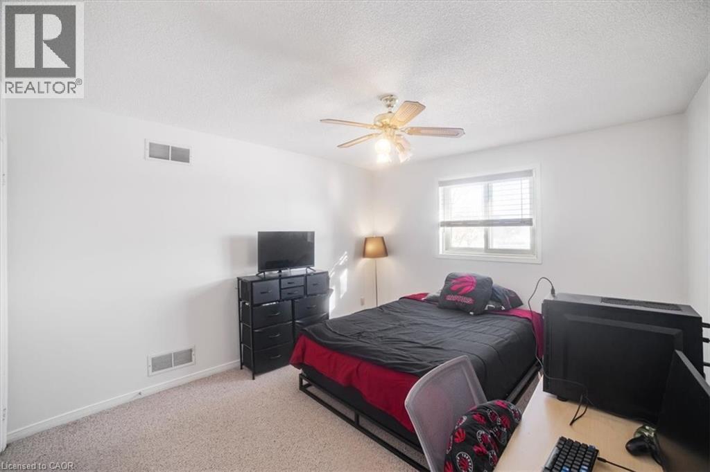 Carpeted bedroom with a textured ceiling and a ceiling fan - 25 Meadowvale Drive Unit# 3, Fonthill, ON - Indoor Photo Showing Bedroom