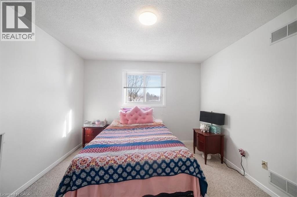 Bedroom with a textured ceiling and light colored carpet - 25 Meadowvale Drive Unit# 3, Fonthill, ON - Indoor Photo Showing Bedroom