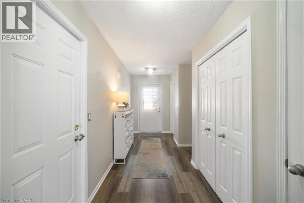 Hall featuring a textured ceiling and dark wood-style floors - 25 Meadowvale Drive Unit# 3, Fonthill, ON - Indoor Photo Showing Other Room