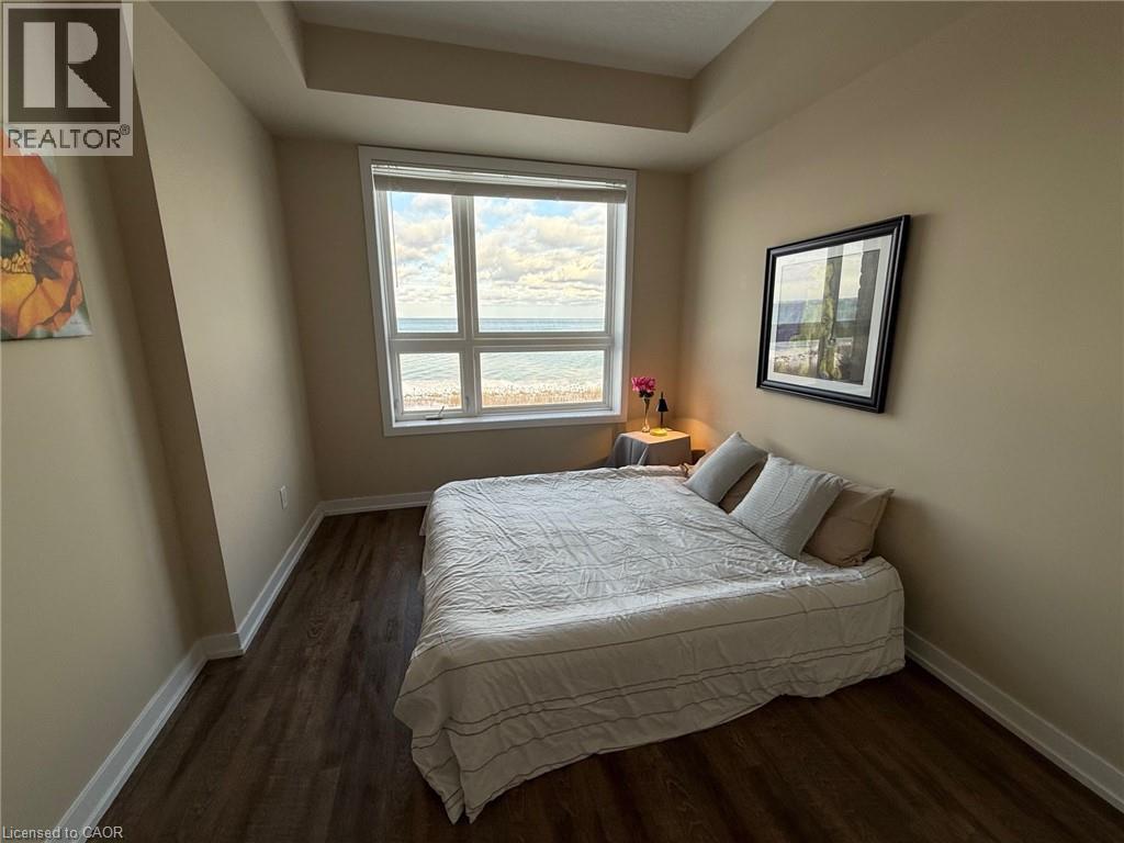 Bedroom featuring dark wood finished floors and a water view - 35 Southshore Crescent Unit# 303, Stoney Creek, ON - Indoor Photo Showing Bedroom