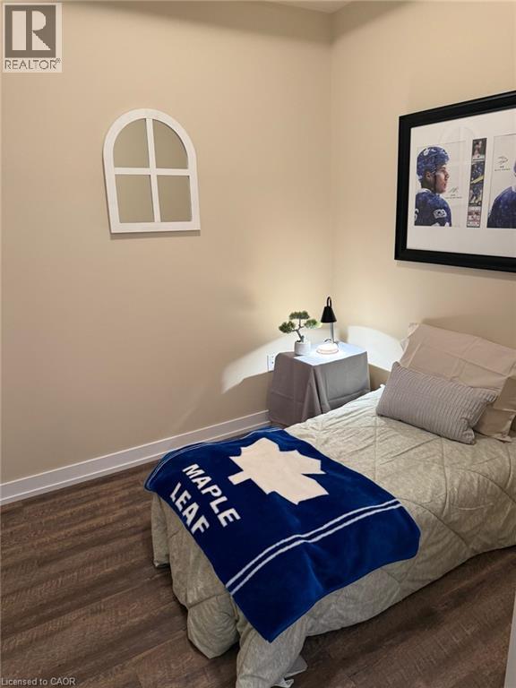 Bedroom with dark wood finished floors and baseboards - 35 Southshore Crescent Unit# 303, Stoney Creek, ON - Indoor Photo Showing Bedroom