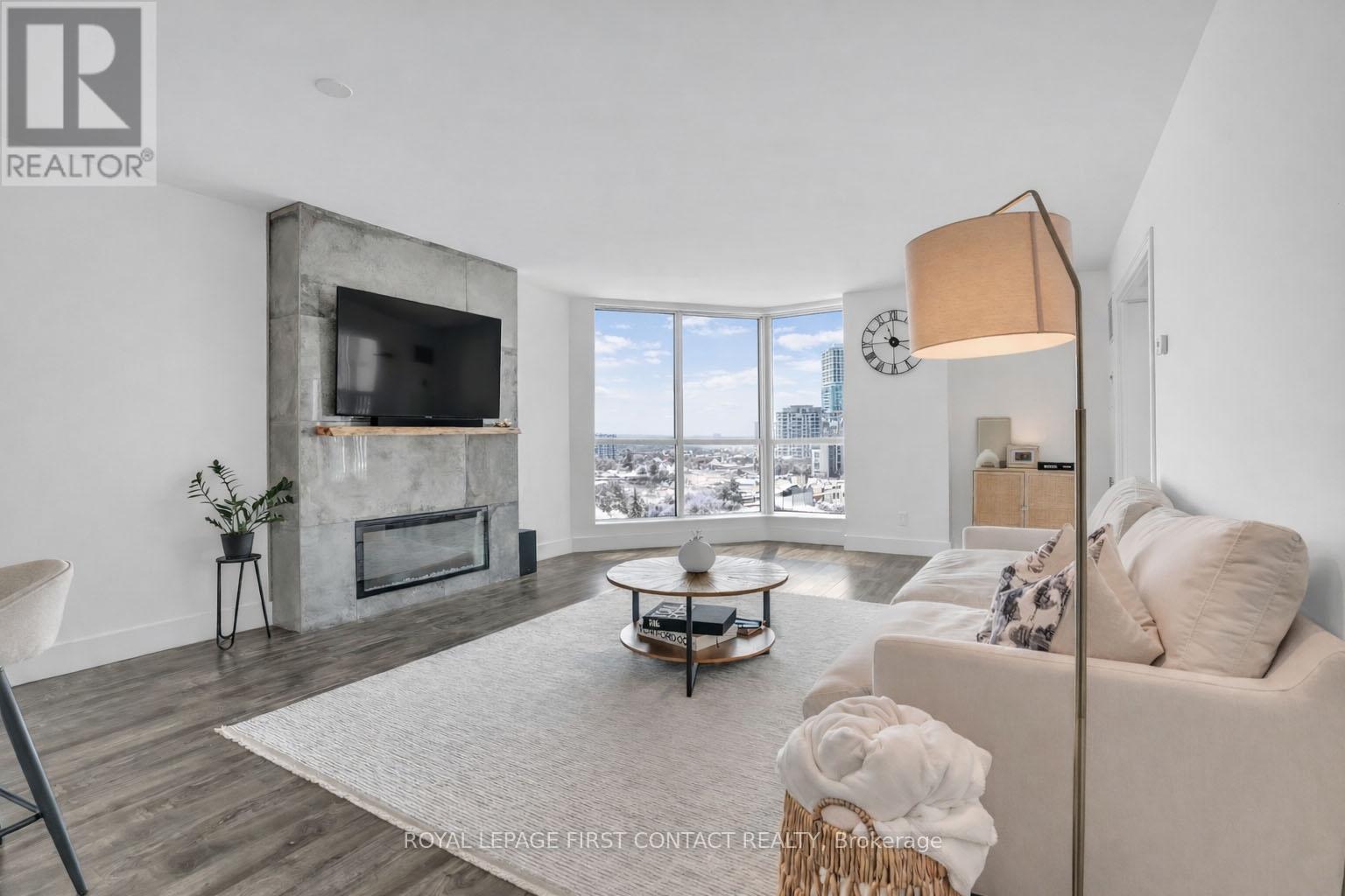 605 - 140 Dunlop Street E, Barrie, ON - Indoor Photo Showing Living Room With Fireplace