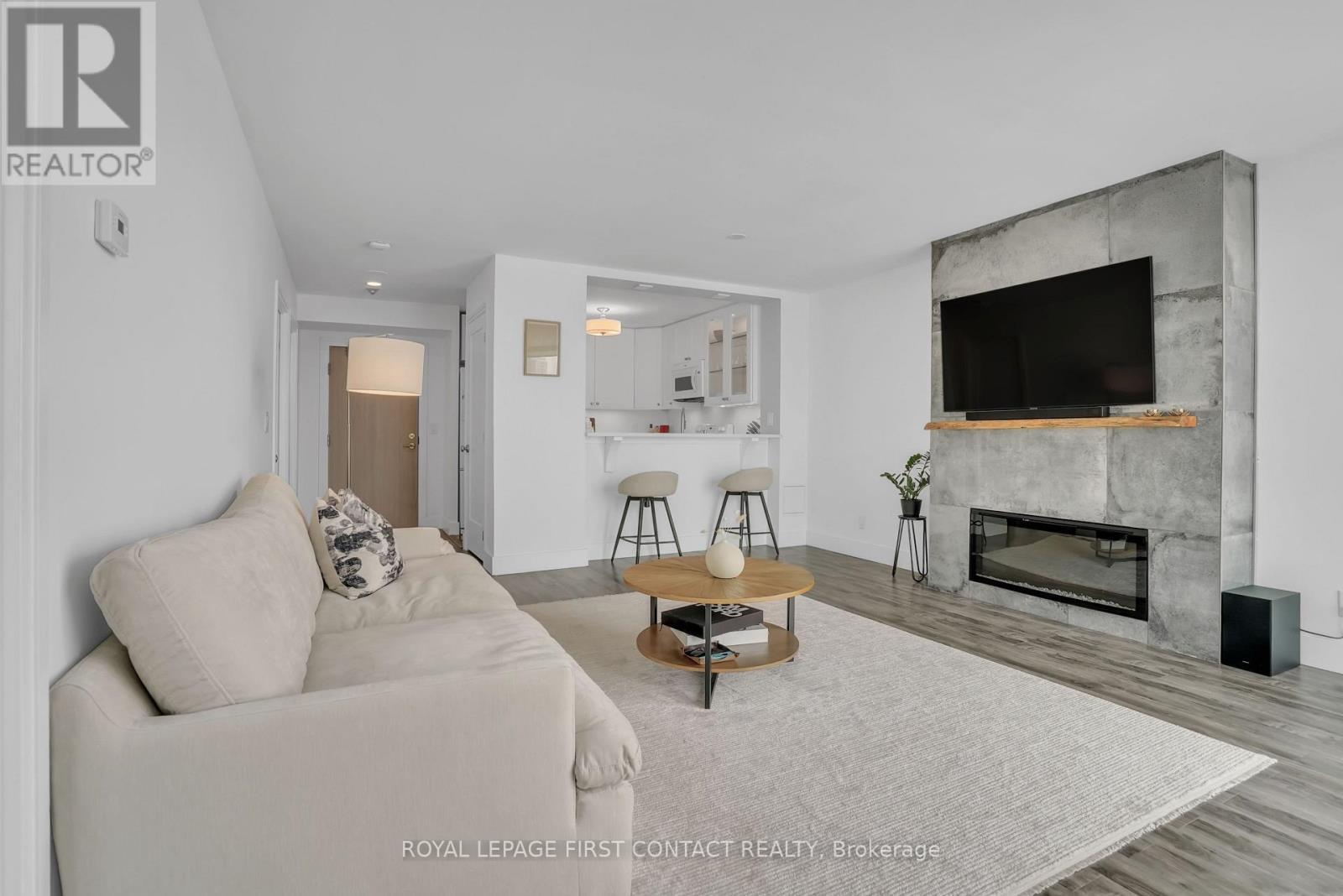 605 - 140 Dunlop Street E, Barrie, ON - Indoor Photo Showing Living Room With Fireplace