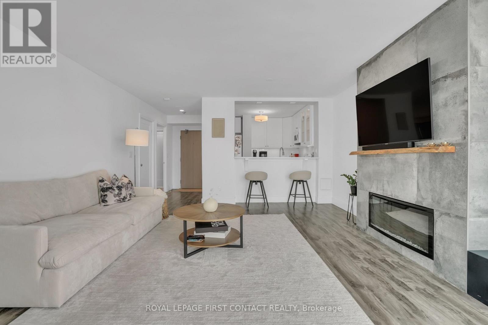 605 - 140 Dunlop Street E, Barrie, ON - Indoor Photo Showing Living Room With Fireplace