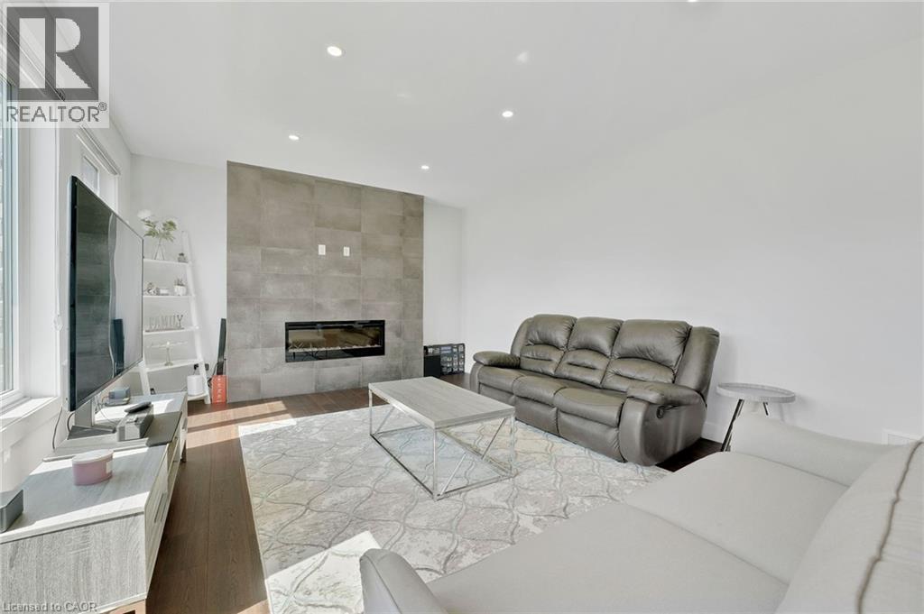 Living room with light wood-style flooring, a fireplace, and recessed lighting - 7266 Silver Creek Circle, London, ON - Indoor Photo Showing Living Room With Fireplace