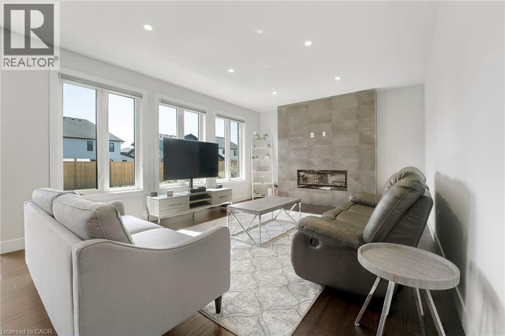 Living area with a fireplace, recessed lighting, and wood finished floors - 7266 Silver Creek Circle, London, ON - Indoor Photo Showing Living Room With Fireplace