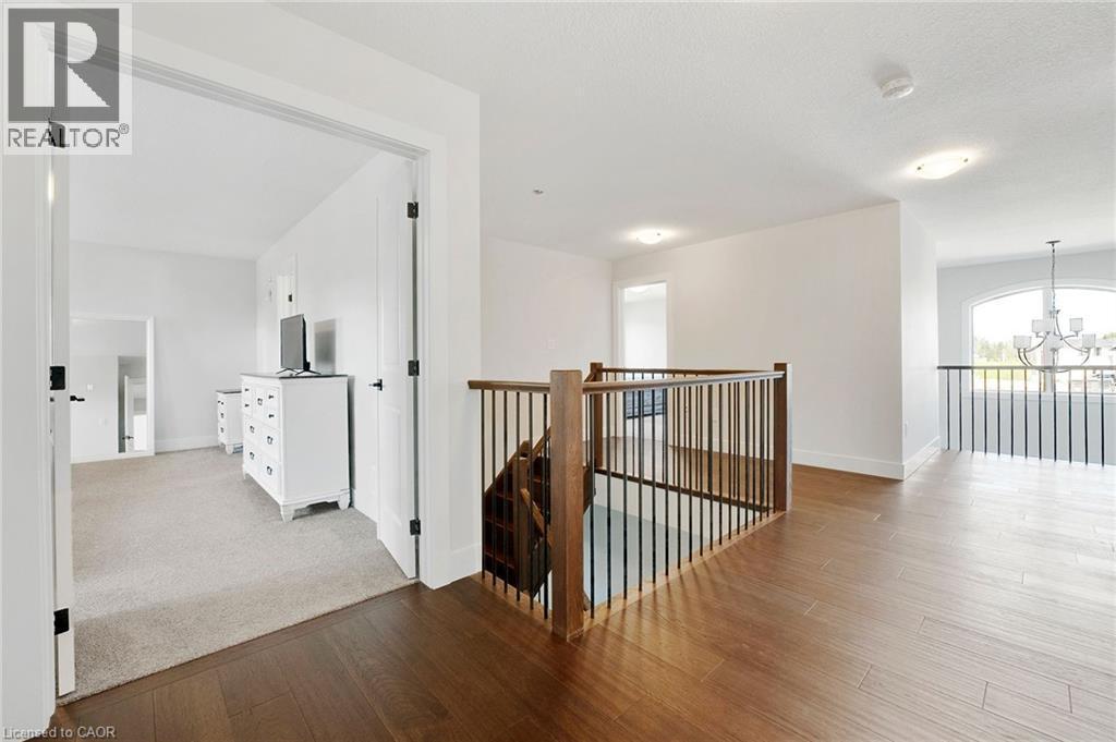 Hall featuring an upstairs landing, a chandelier, and wood finished floors - 7266 Silver Creek Circle, London, ON - Indoor Photo Showing Other Room