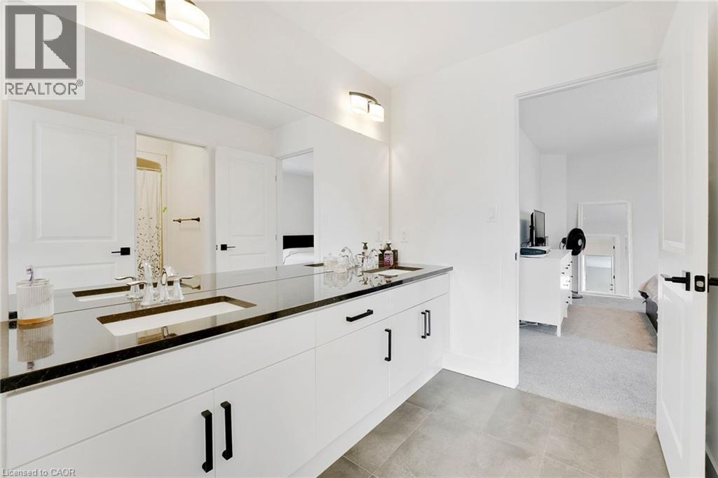 Bathroom featuring double vanity and light colored carpet - 7266 Silver Creek Circle, London, ON - Indoor