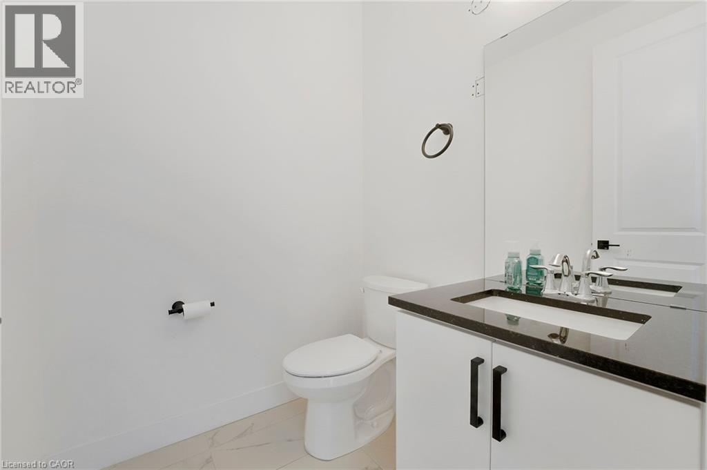 Half bath with vanity and light marble finish flooring - 7266 Silver Creek Circle, London, ON - Indoor Photo Showing Bathroom