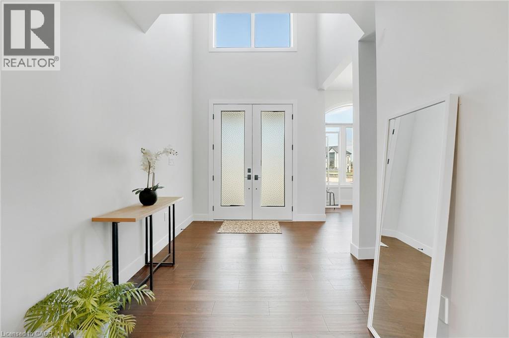 Entrance foyer with healthy amount of natural light, french doors, a high ceiling, and dark wood-type flooring - 7266 Silver Creek Circle, London, ON - Indoor Photo Showing Other Room