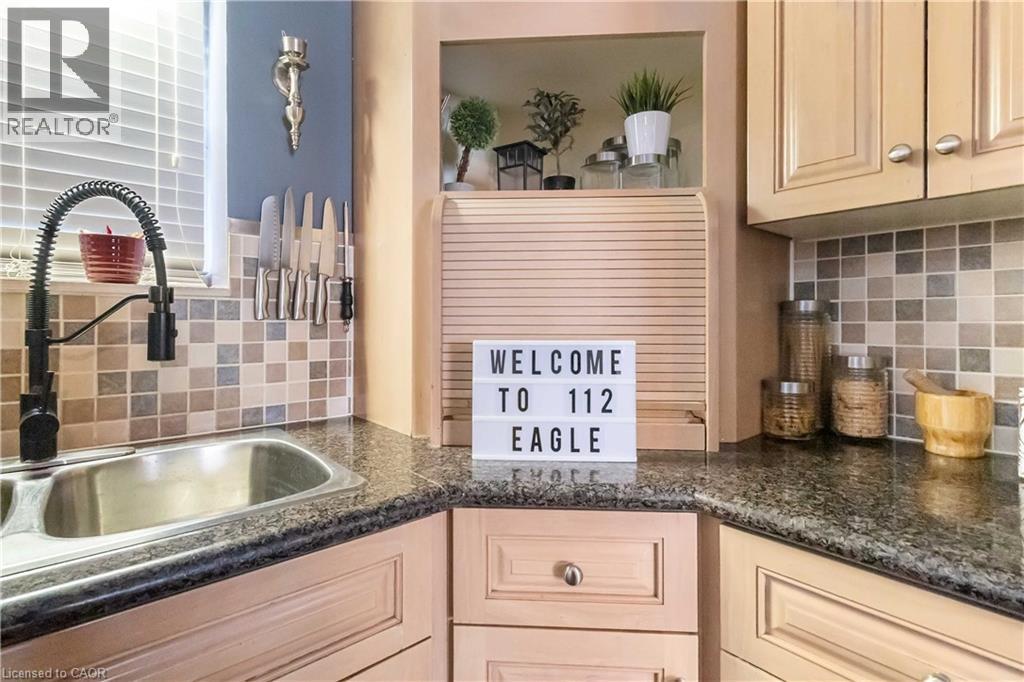 Kitchen featuring decorative backsplash, light brown cabinets, and dark stone counters - 112 Eagle Avenue, Brantford, ON - Indoor Photo Showing Kitchen