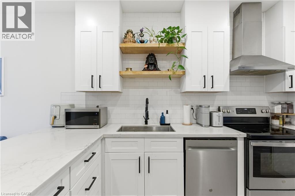 Kitchen with stainless steel appliances, open shelves, wall chimney range hood, and white cabinets - 40 Fullerton Avenue, Hamilton, ON - Indoor Photo Showing Kitchen With Upgraded Kitchen