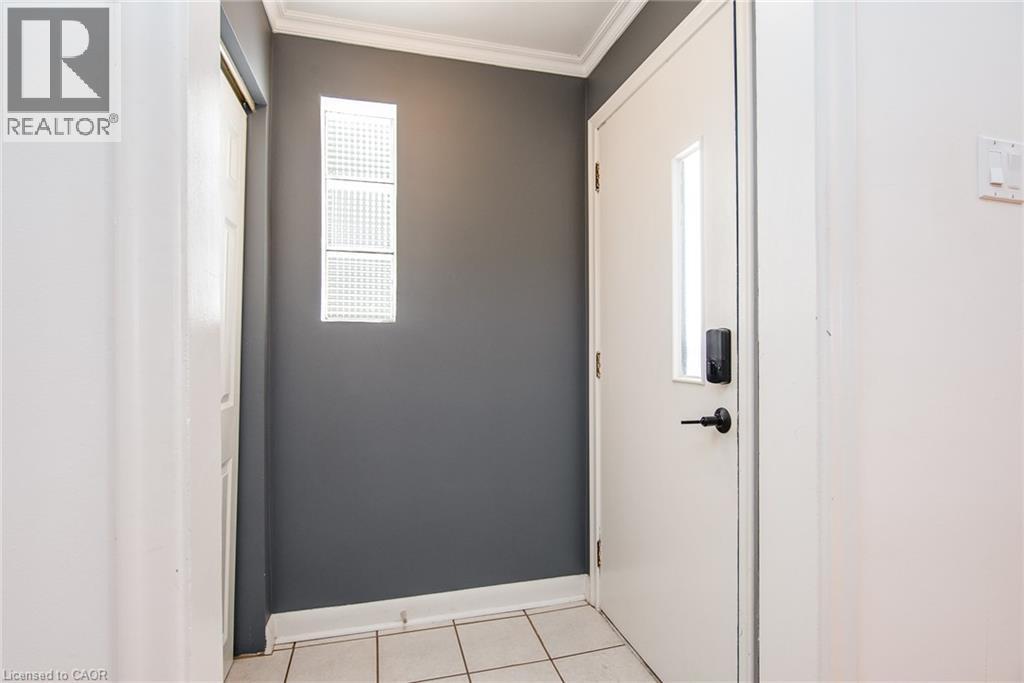 Doorway to outside with crown molding and tile patterned floors - 120 Fourth Avenue, Kitchener, ON - Indoor Photo Showing Other Room