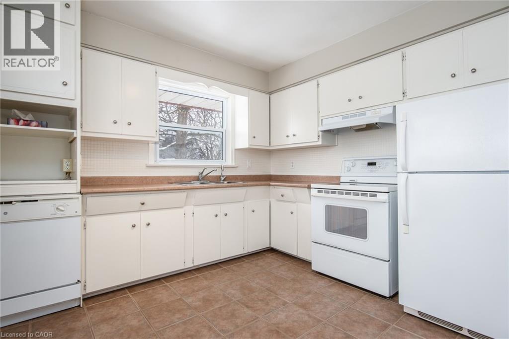 Kitchen featuring white appliances, light countertops, white cabinets, and open shelves - 120 Fourth Avenue, Kitchener, ON - Indoor Photo Showing Kitchen With Double Sink