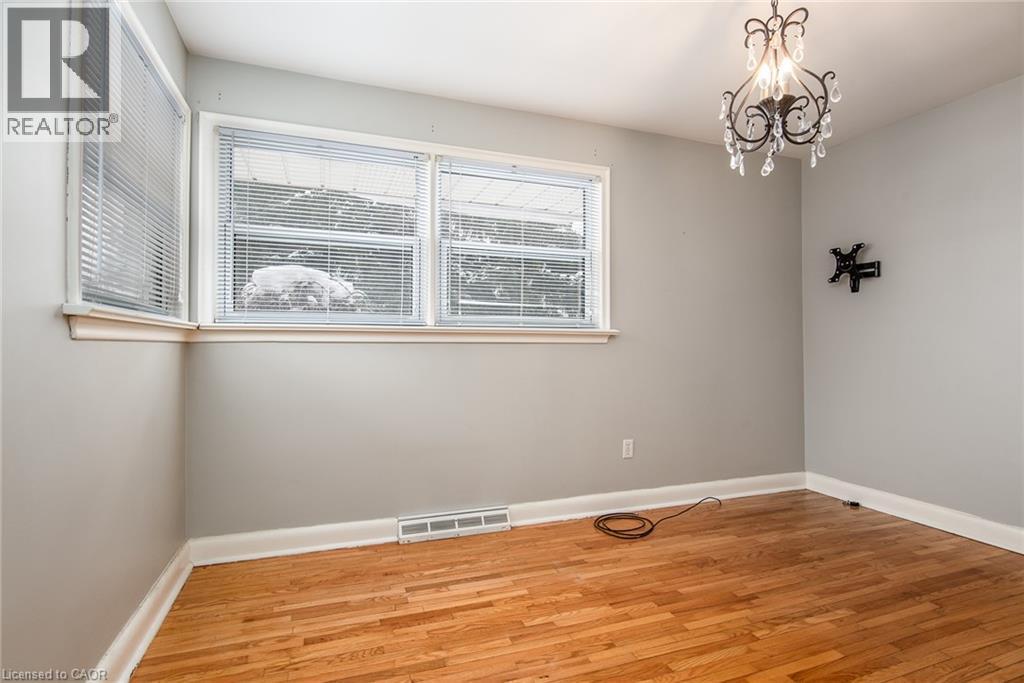 Unfurnished room featuring light wood finished floors and suspended lighting - 120 Fourth Avenue, Kitchener, ON - Indoor Photo Showing Other Room