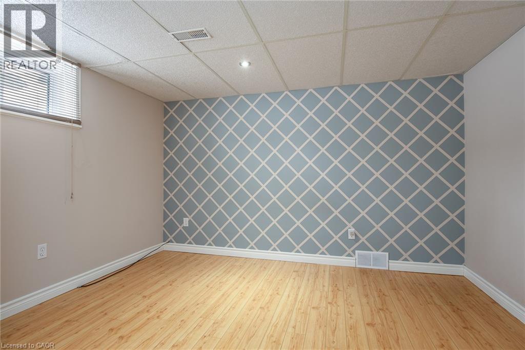 Empty room featuring an accent wall, wallpapered walls, light wood finished floors, a drop ceiling, and recessed lighting - 120 Fourth Avenue, Kitchener, ON - Indoor Photo Showing Other Room