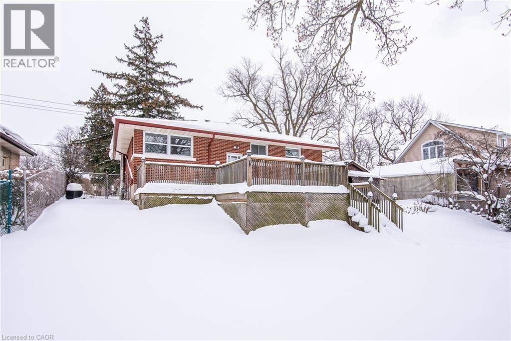 Snow covered back of property featuring a wooden deck and brick siding - 120 Fourth Avenue, Kitchener, ON - Outdoor