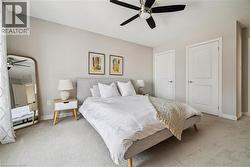 Carpeted bedroom featuring a ceiling fan and baseboards -
