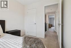 Unfurnished bedroom with light carpet and baseboards -