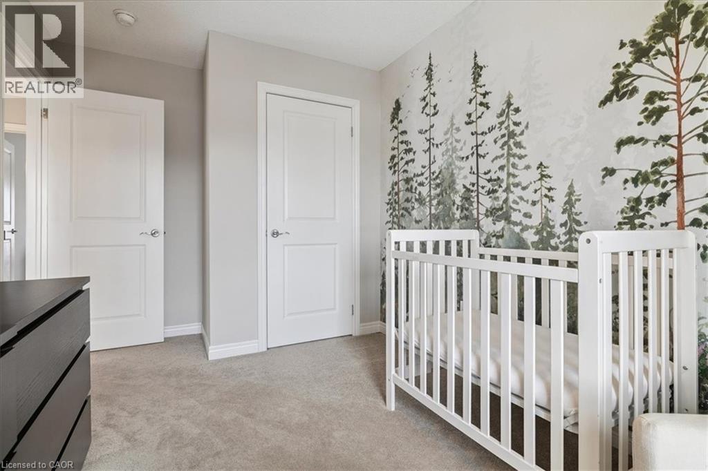 Bedroom featuring a crib and light carpet - 2220 Queensway Drive Unit# 15, Burlington, ON - Indoor Photo Showing Bedroom