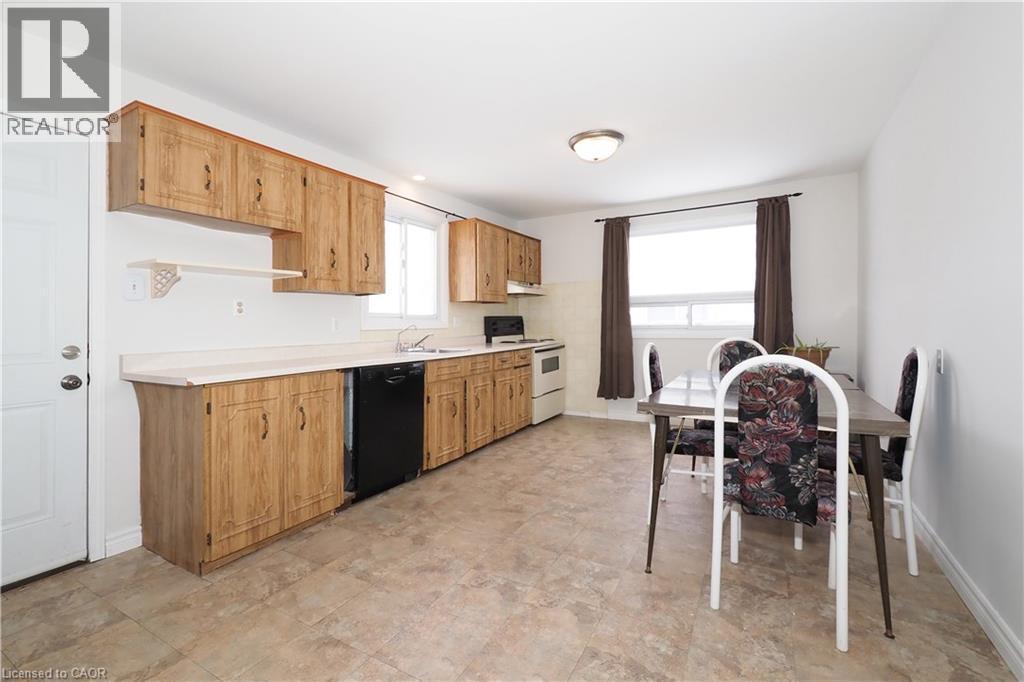 Kitchen featuring light countertops, white stove, and black dishwasher - 10 Balfour Crescent, Kitchener, ON - Indoor