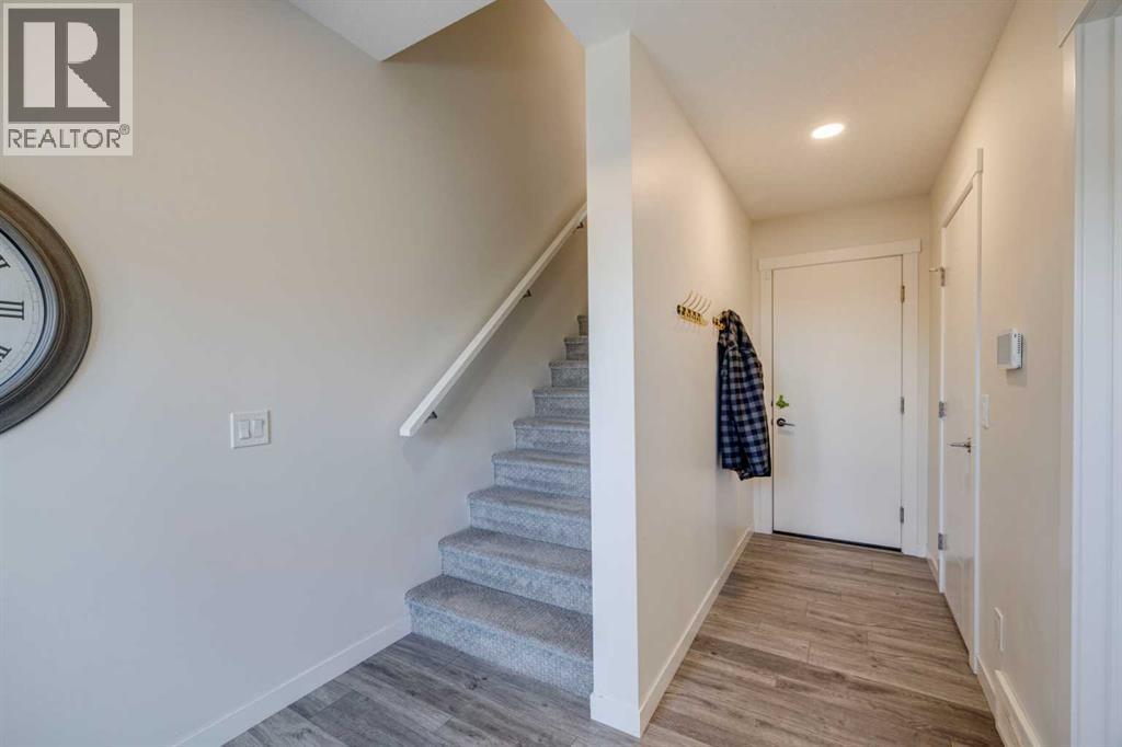 Hallway to garage and utility room as well as stairs to the main level - 614 Greenbriar Common Nw, Calgary, AB - Indoor Photo Showing Other Room
