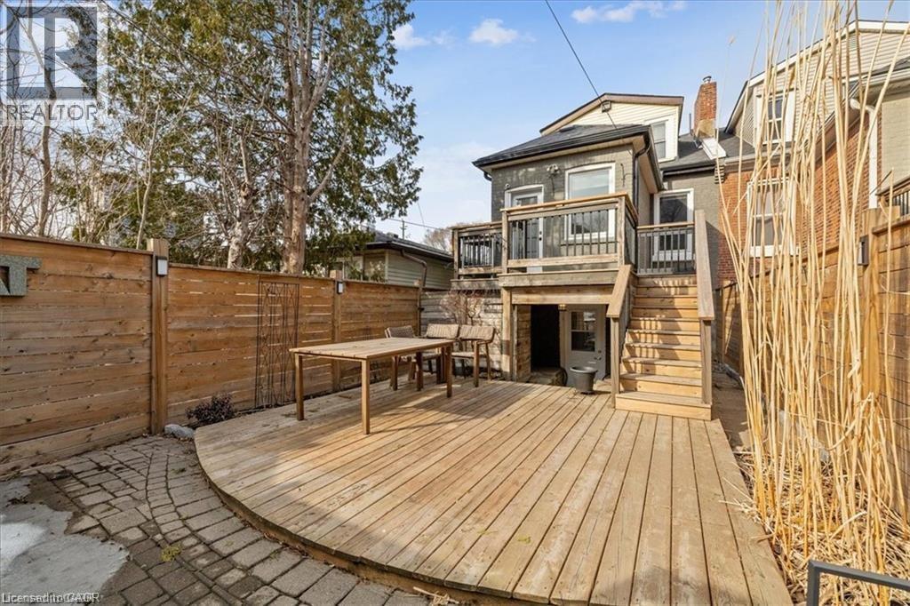 Deck with stairway, a fenced backyard, and outdoor dining space - 28 Grove Street, Hamilton, ON - Outdoor With Deck Patio Veranda