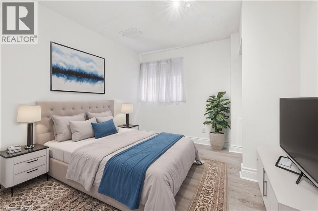 Bedroom with light wood-type flooring and baseboards - 28 Grove Street, Hamilton, ON - Indoor Photo Showing Bedroom