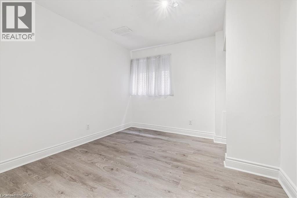 Empty room featuring light wood-style floors and baseboards - 28 Grove Street, Hamilton, ON - Indoor Photo Showing Other Room