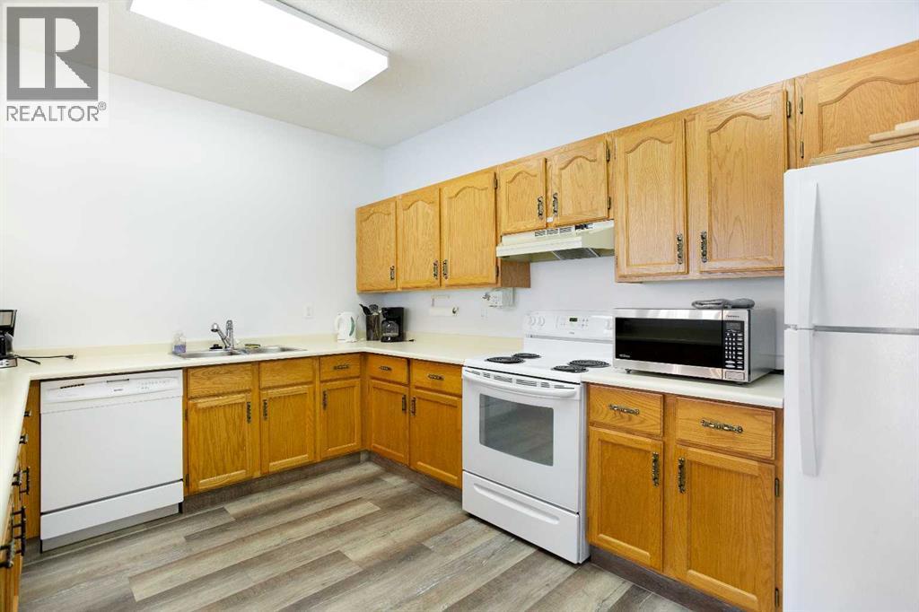 Amenities Building - Downstairs - 8, 118 Strathcona Road Sw, Calgary, AB - Indoor Photo Showing Kitchen With Double Sink