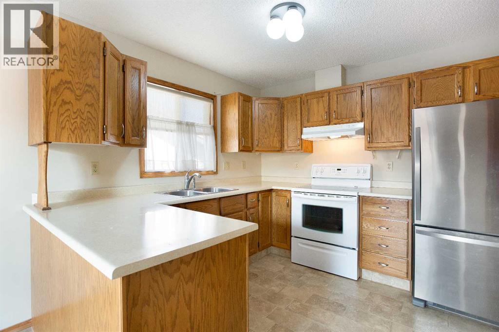 8, 118 Strathcona Road Sw, Calgary, AB - Indoor Photo Showing Kitchen With Double Sink