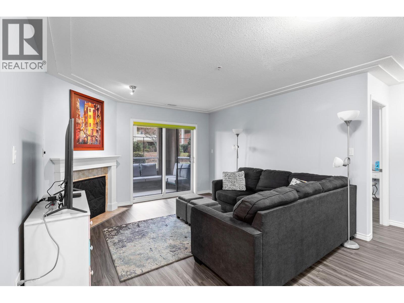 Living Room with Sliding doors to outdoor living space - 1966 Durnin Road Unit# 105, Kelowna, BC - Indoor Photo Showing Living Room With Fireplace