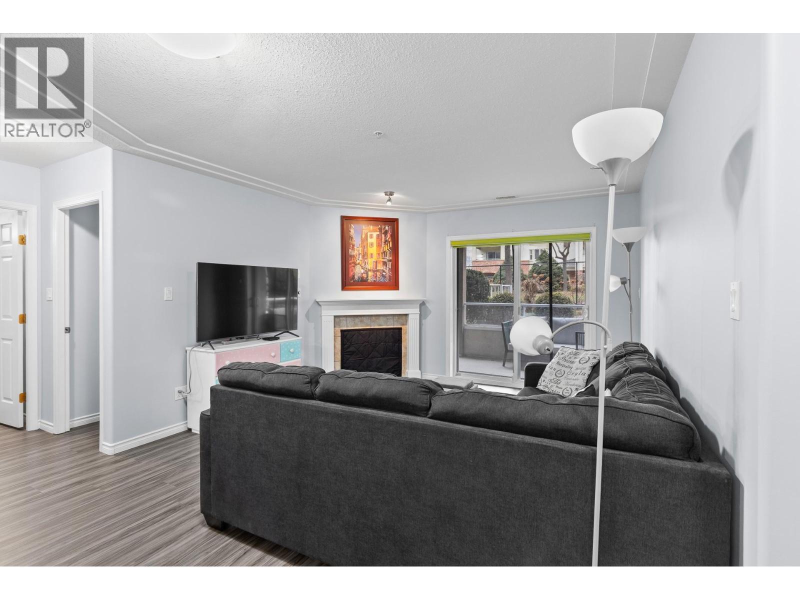 Living Room with Sliding doors to outdoor living space - 1966 Durnin Road Unit# 105, Kelowna, BC - Indoor Photo Showing Living Room With Fireplace