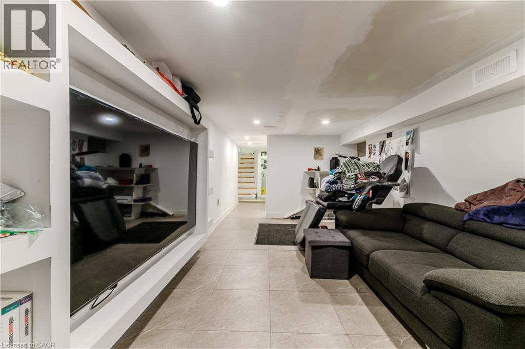 Living room featuring light tile patterned floors, recessed lighting, and stairs - 126 Tisdale Street N, Hamilton, ON - Indoor