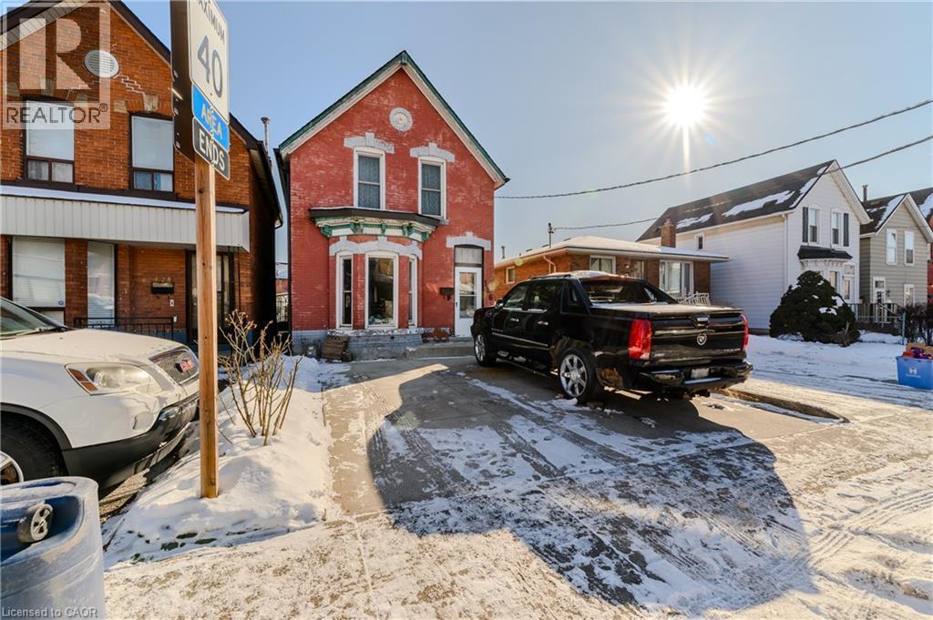 View of front facade featuring brick siding and a residential view - 126 Tisdale Street N, Hamilton, ON - Outdoor
