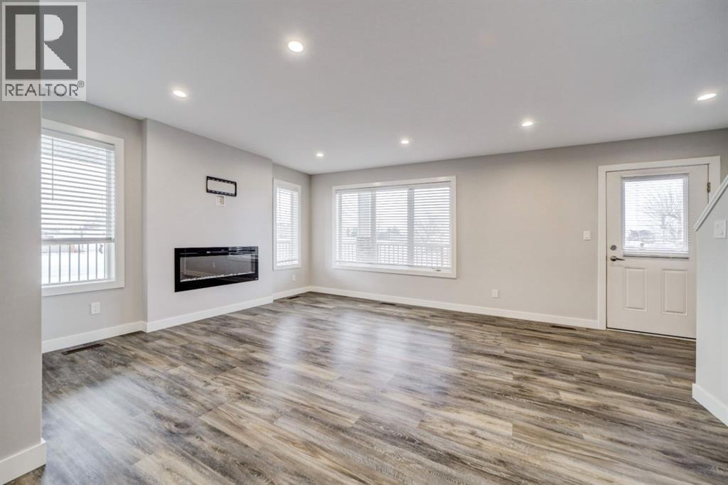 Living Room - 203 1 Street, Shaughnessy, AB - Indoor Photo Showing Other Room With Fireplace