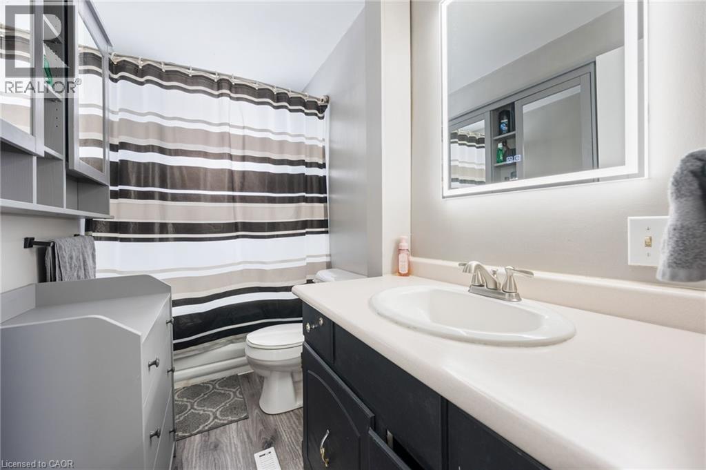 Bathroom with vanity, a shower with shower curtain, and dark wood finished floors - 234 Head Street N, Simcoe, ON - Indoor Photo Showing Bathroom