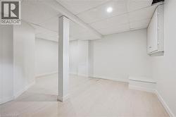 Finished below grade area with a paneled ceiling and light wood-style flooring -