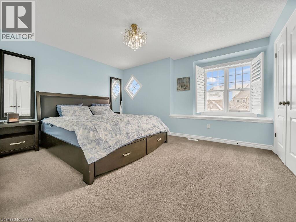 Carpeted bedroom featuring a textured ceiling and a chandelier - 29 Amsterdam Crescent, Guelph, ON - Indoor Photo Showing Bedroom