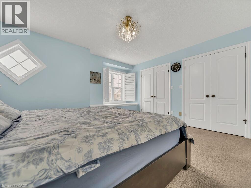 Bedroom with two closets, carpet, a textured ceiling, and a chandelier - 29 Amsterdam Crescent, Guelph, ON - Indoor Photo Showing Bedroom
