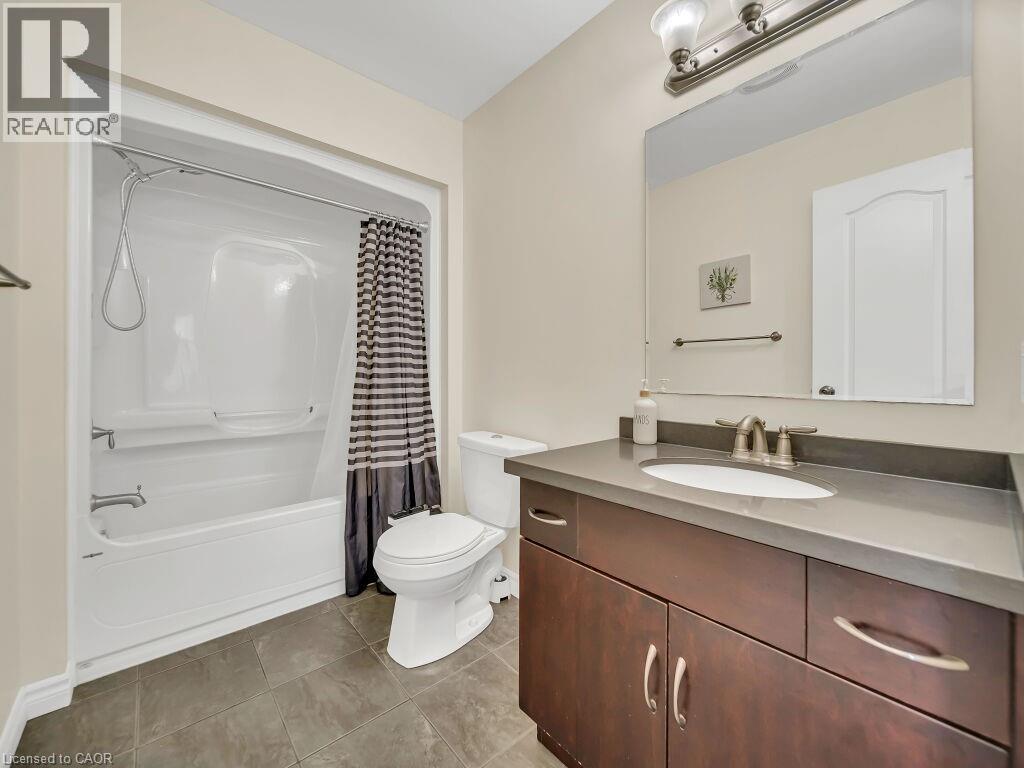 Full bath featuring vanity, shower / bath combo with shower curtain, and light tile patterned floors - 29 Amsterdam Crescent, Guelph, ON - Indoor Photo Showing Bathroom