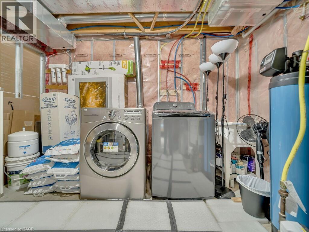 Laundry room featuring water heater and washing machine and clothes dryer - 29 Amsterdam Crescent, Guelph, ON - Indoor Photo Showing Laundry Room