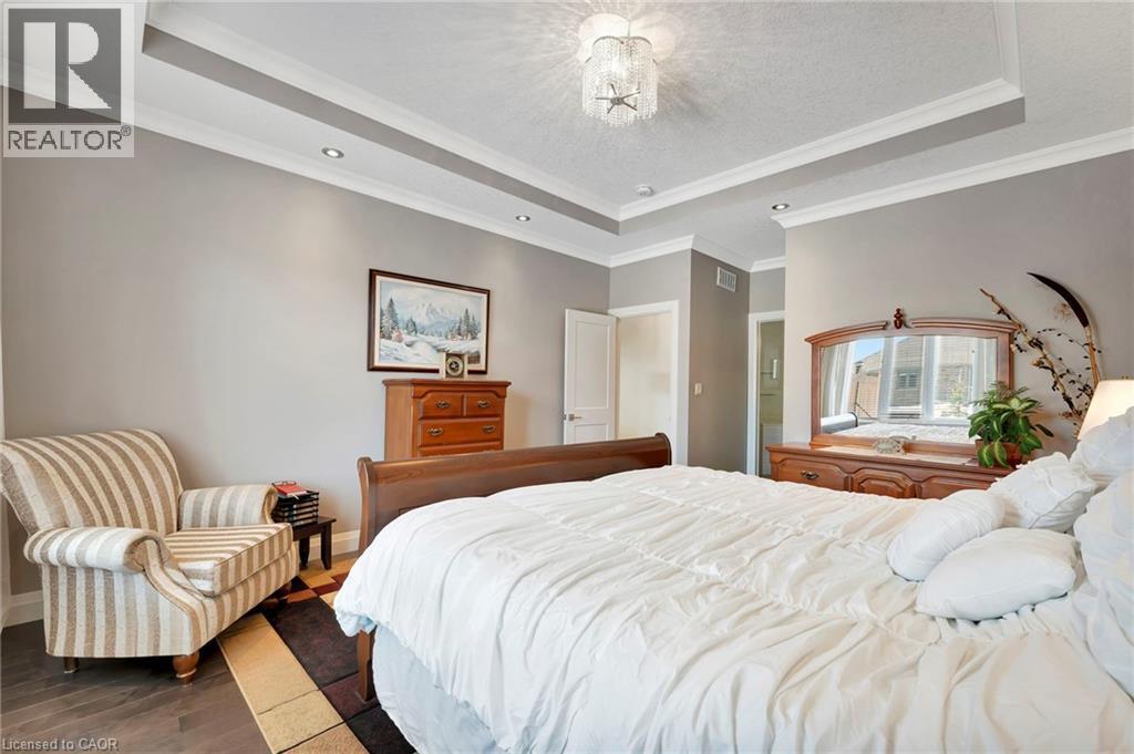 Bedroom with wood finished floors, crown molding, a tray ceiling, and a textured ceiling - 107 Forbes Crescent, Listowel, ON - Indoor Photo Showing Bedroom