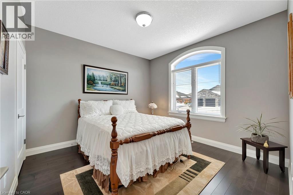 Bedroom featuring dark wood-style floors and a textured ceiling - 107 Forbes Crescent, Listowel, ON - Indoor Photo Showing Bedroom