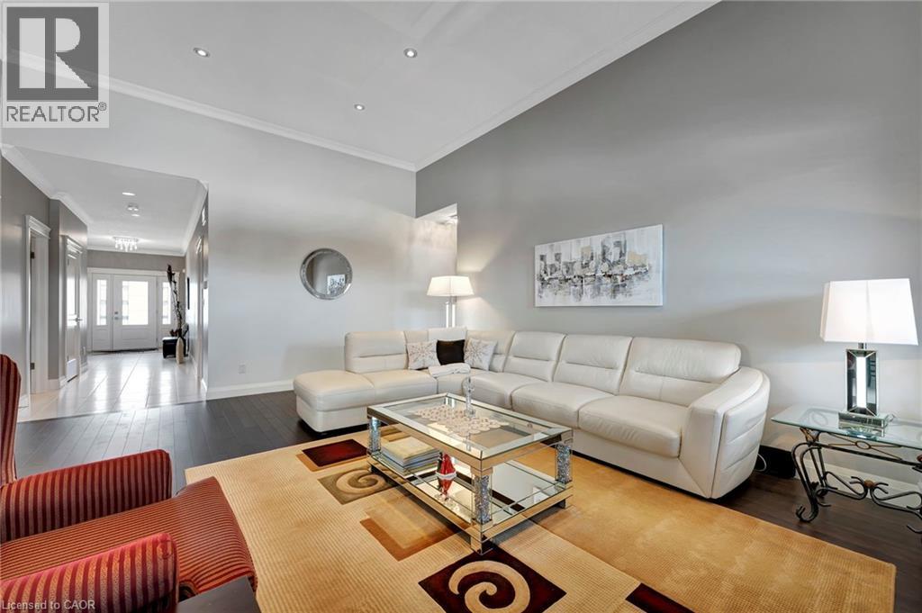 Living room featuring dark wood-type flooring, crown molding, and recessed lighting - 107 Forbes Crescent, Listowel, ON - Indoor Photo Showing Living Room