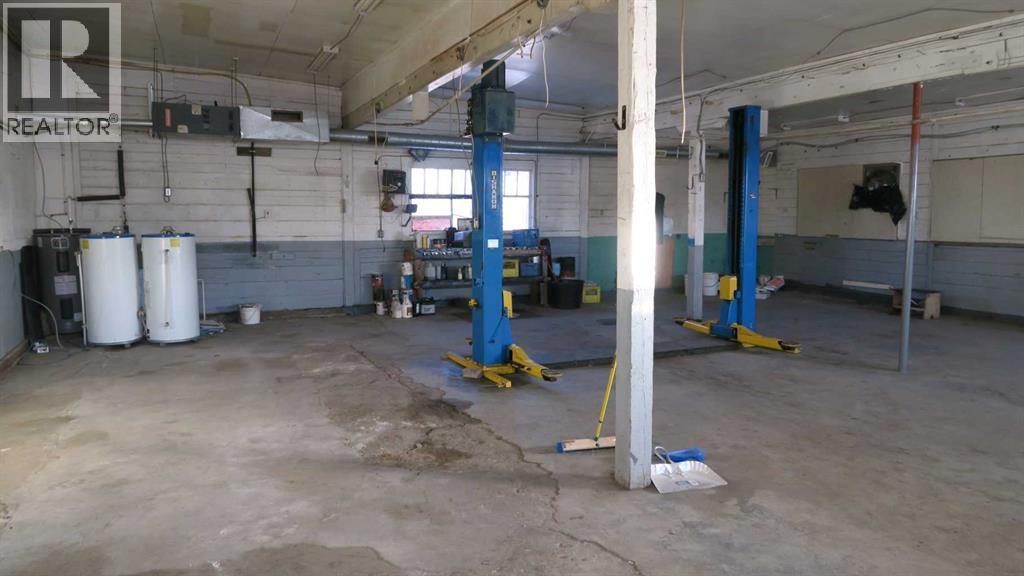 Concrete Floor With Hoist - 208 4 Avenue, Gleichen, AB - Indoor Photo Showing Garage