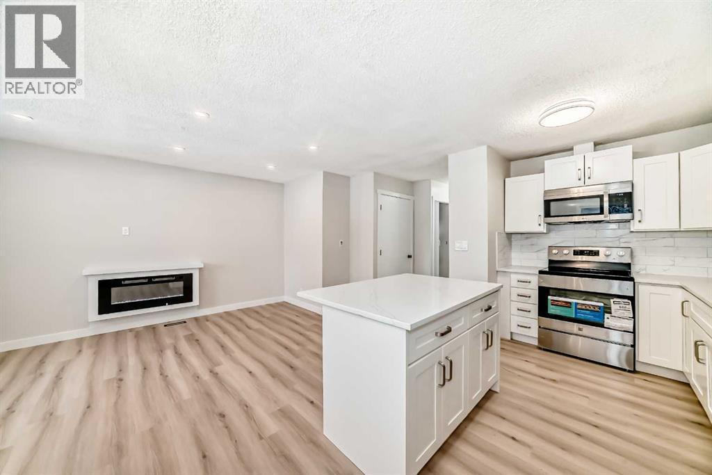 937 Marcombe Drive Ne, Calgary, AB - Indoor Photo Showing Kitchen With Fireplace