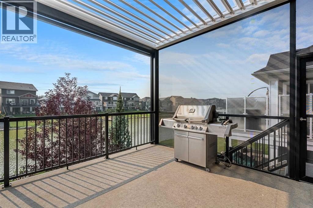 This custom, extended back deck impresses with natural sunlight and sun coast screens - 2253 Bayside Road Sw, Airdrie, AB - Outdoor With Exterior