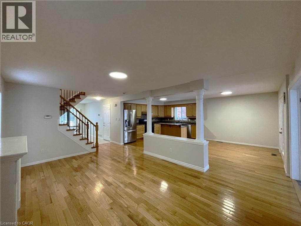 Unfurnished living room with stairs, light wood finished floors, ornate columns, and recessed lighting - 443 Lausanne Crescent, Waterloo, ON - Indoor Photo Showing Other Room
